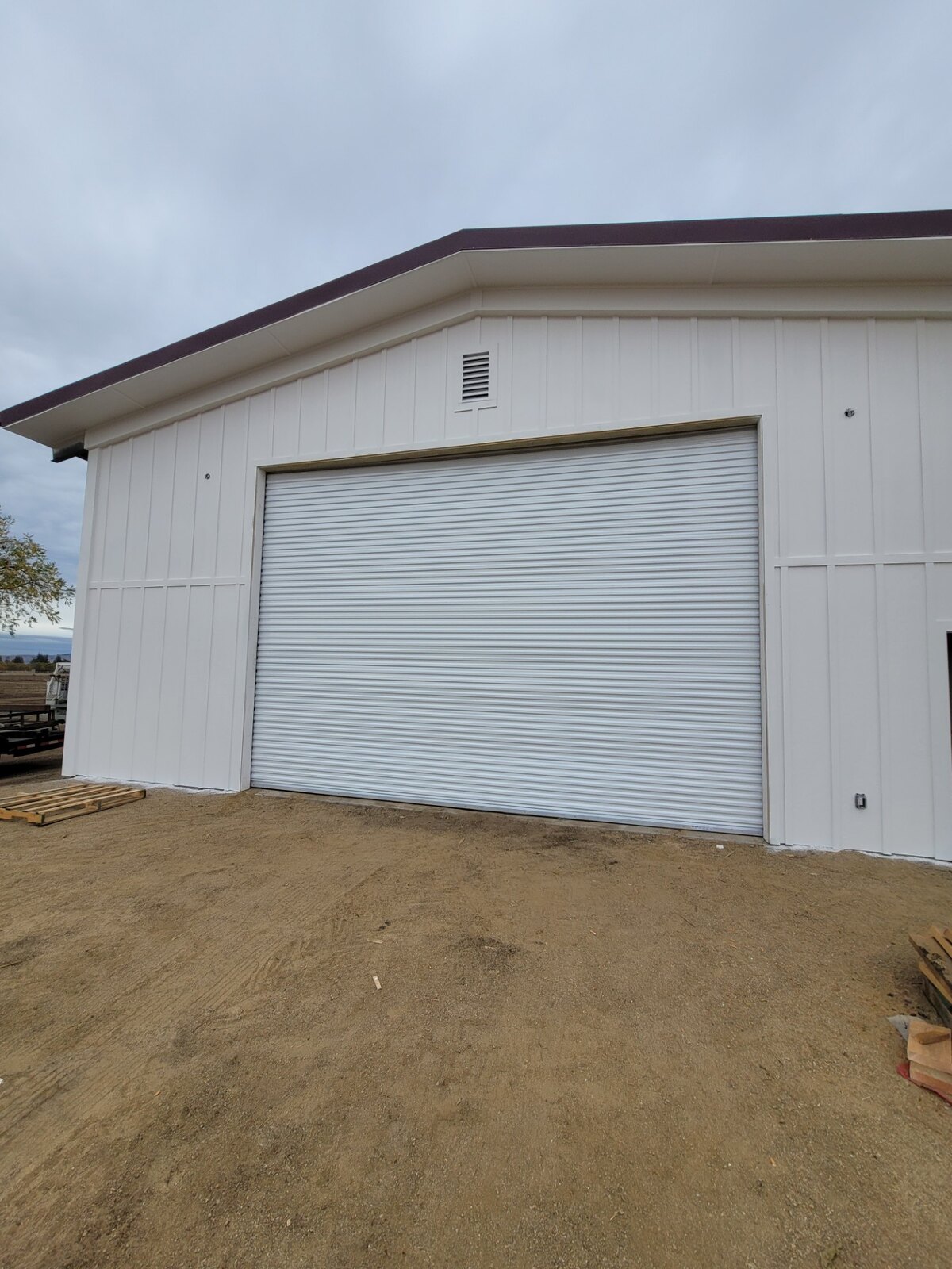 White commercial sectional overhead door on a metal building
