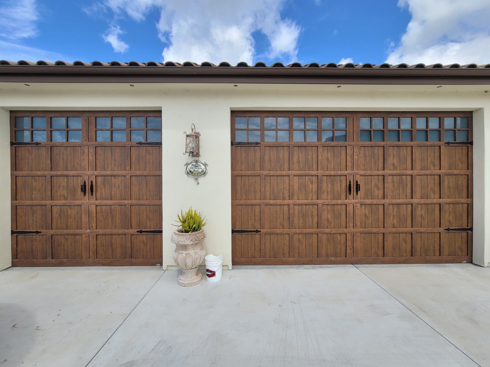 Wood-look carriage garage doors on a tan stucco home
