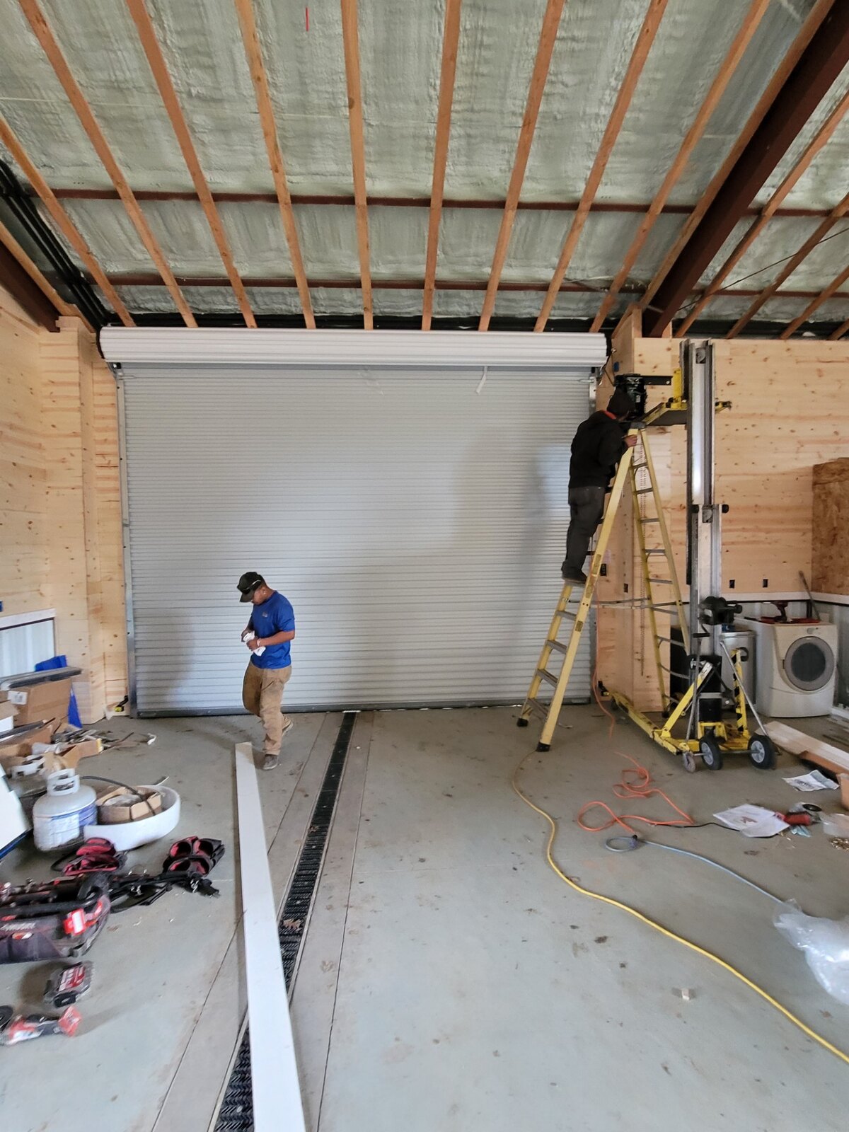 Technician installing a commercial overhead door