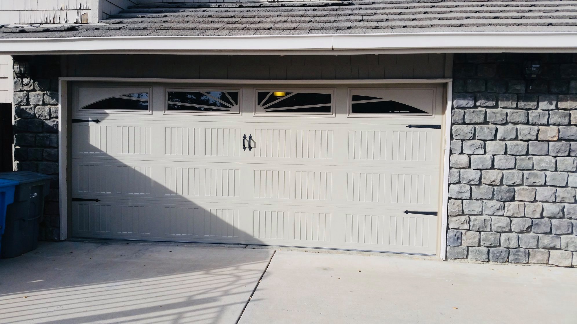 Stone-accented home with a finished garage door