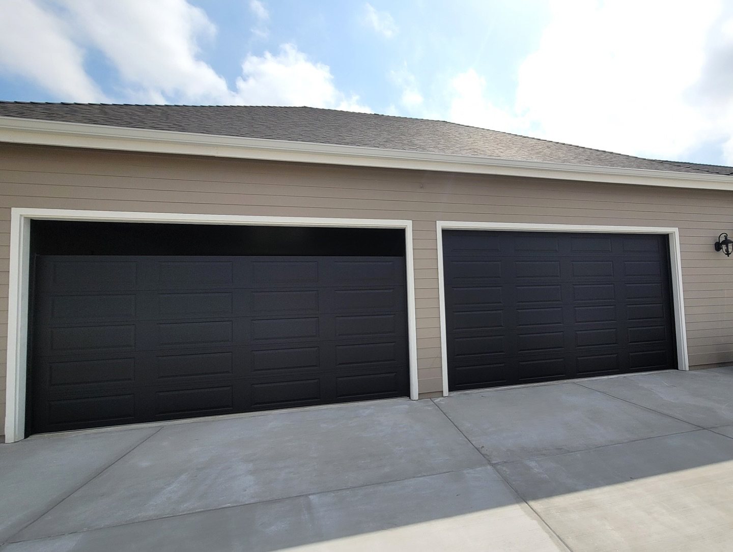 Three-car garage with dark modern sectional doors