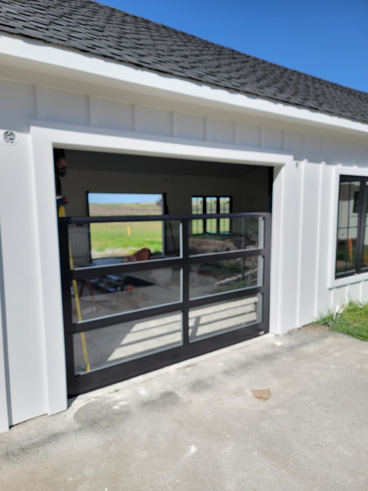 Black-framed full-view glass garage doors on a modern home