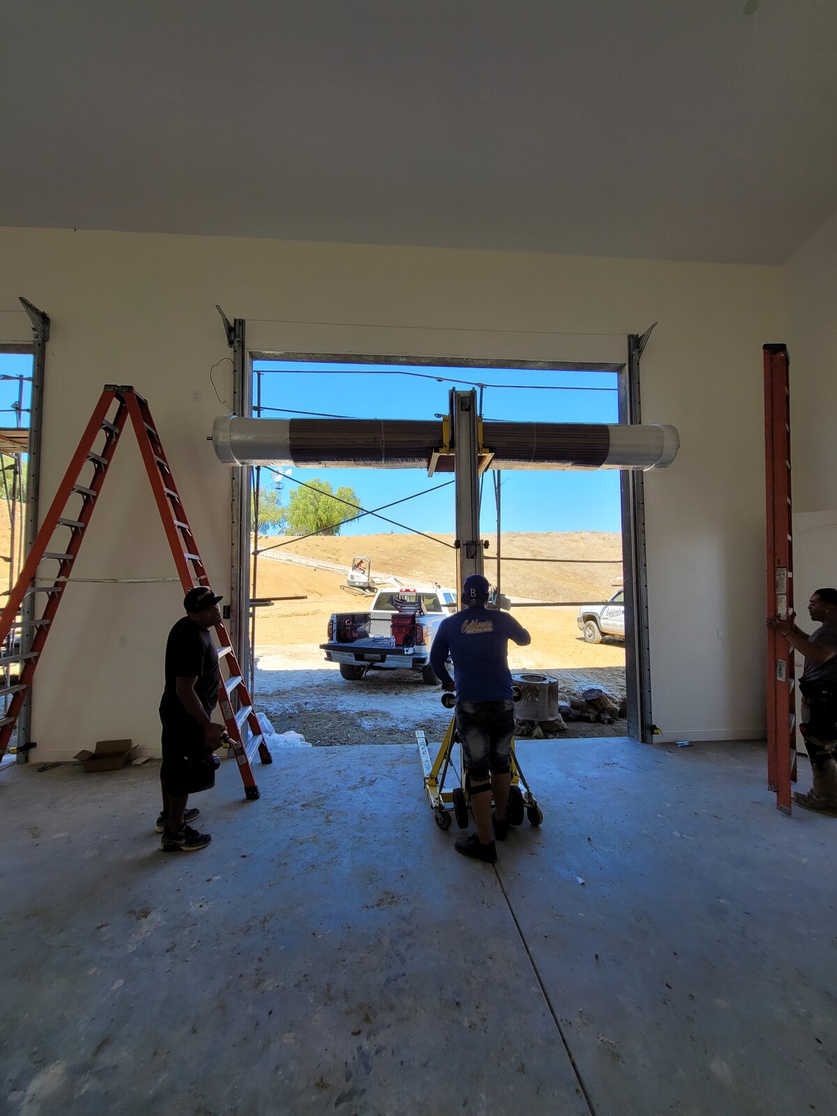 Commercial overhead door installation with crew on site