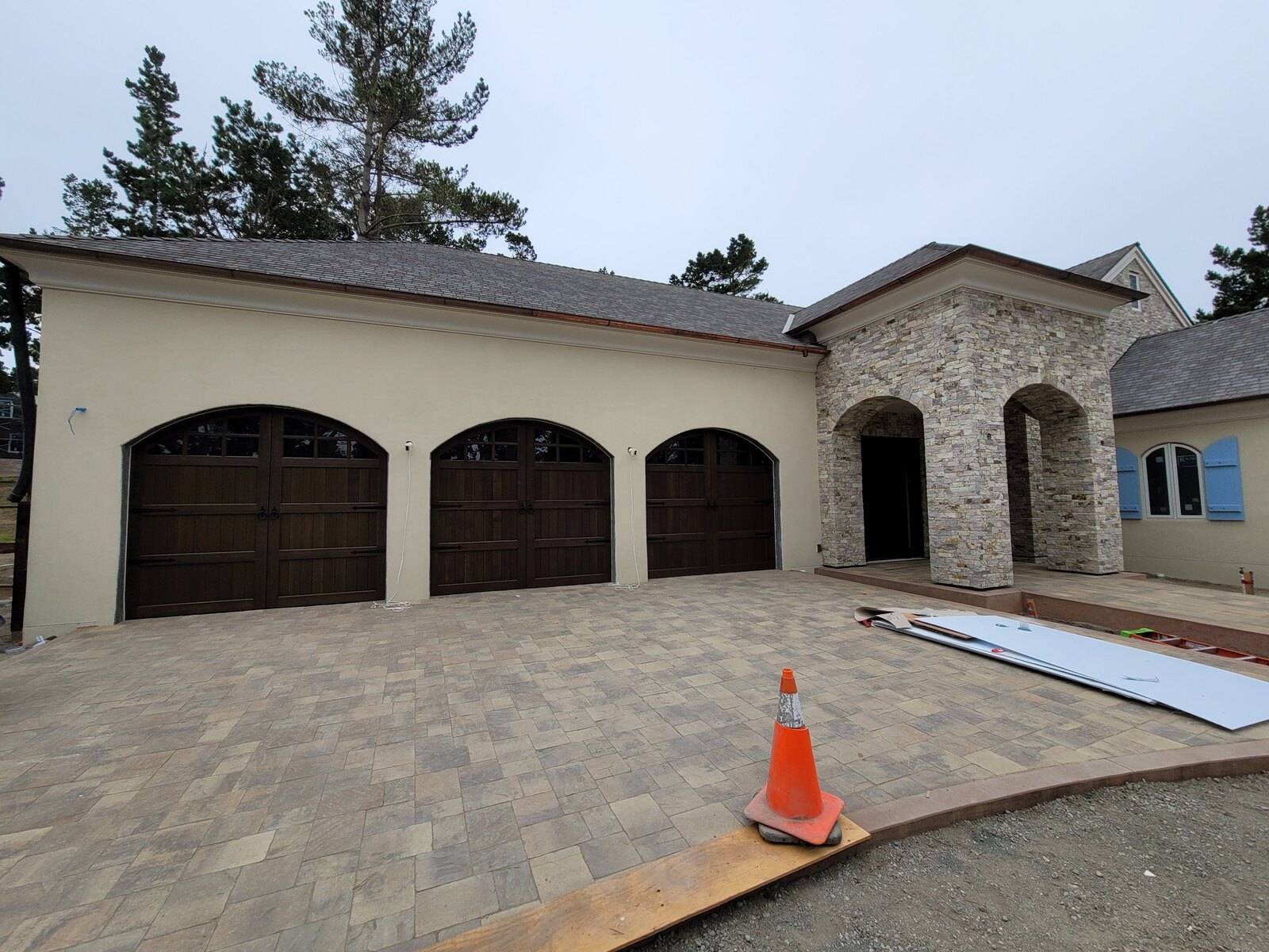 Estate home with multiple arched wood garage doors on the Central Coast
