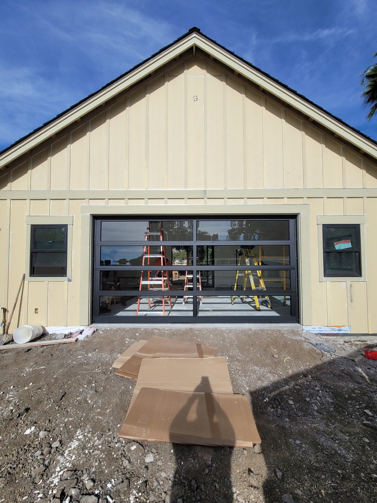 Full-view glass garage door install on a hillside home