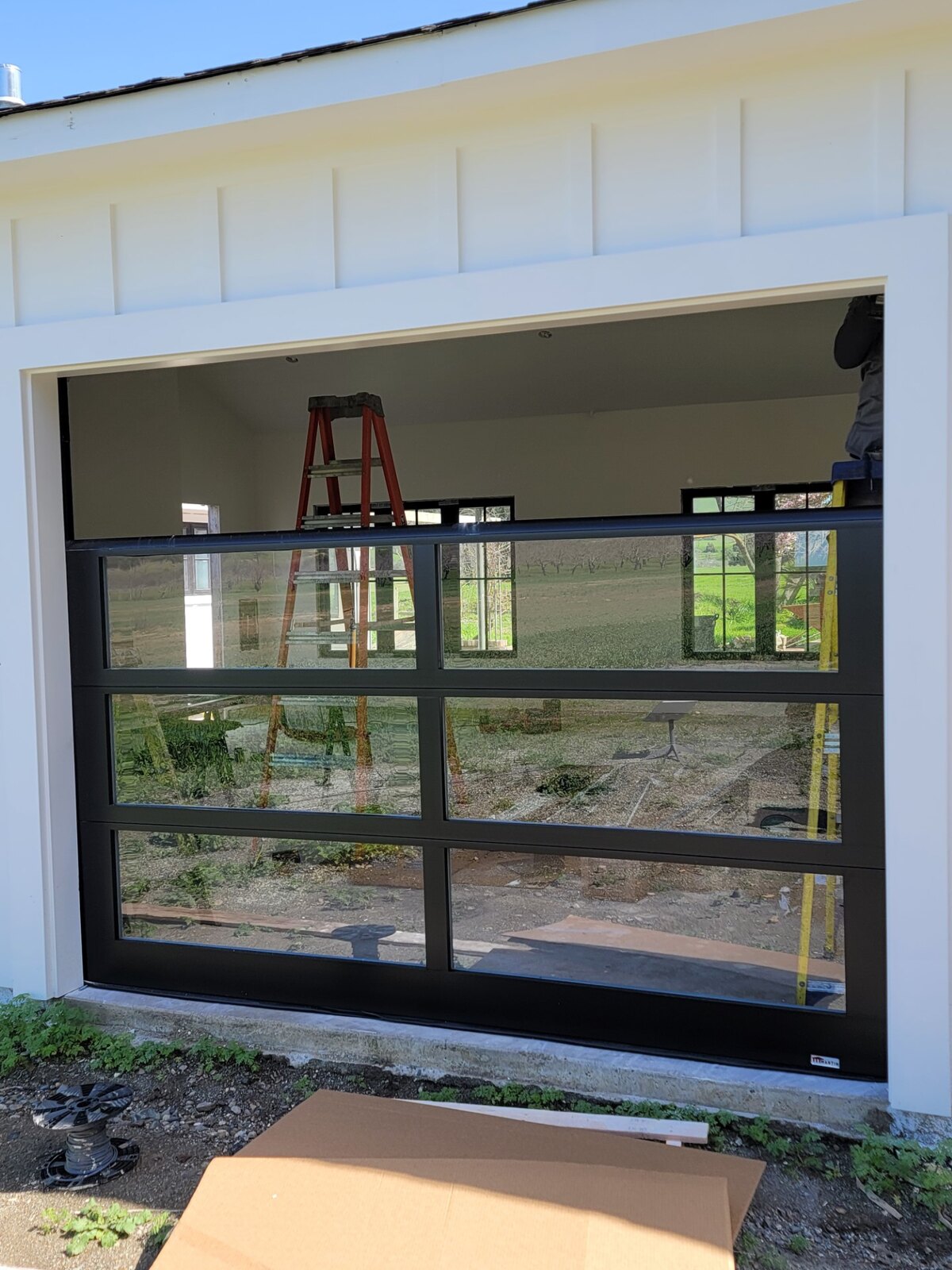 Full-view glass garage door with service truck in the driveway