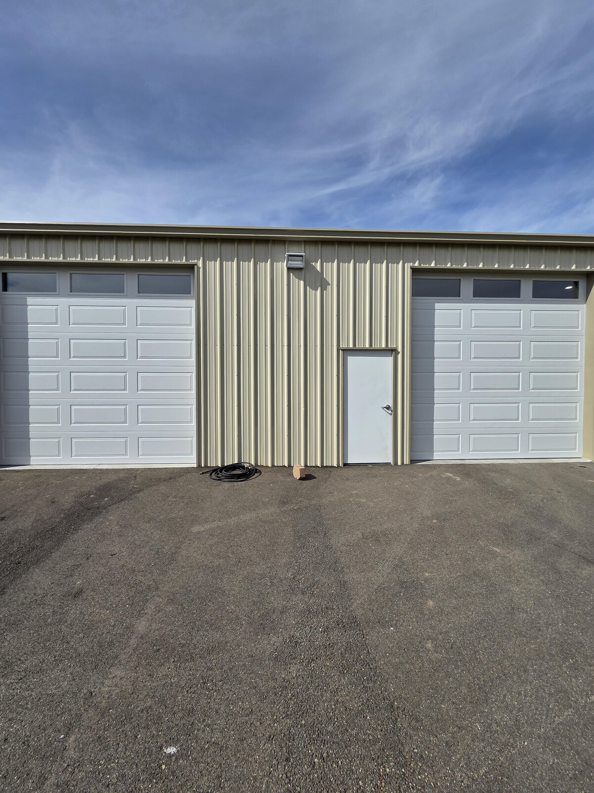 Two commercial sectional overhead doors on a metal building