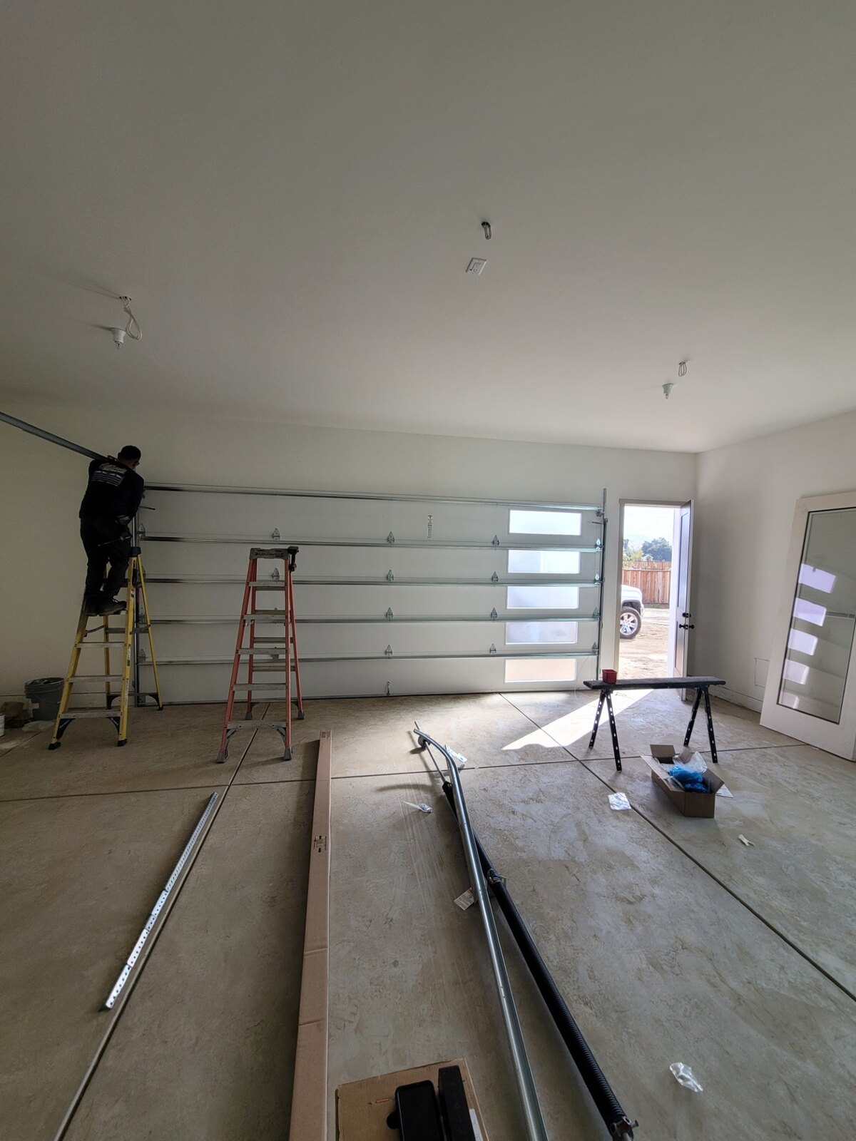 Technician installing a full-view glass garage door