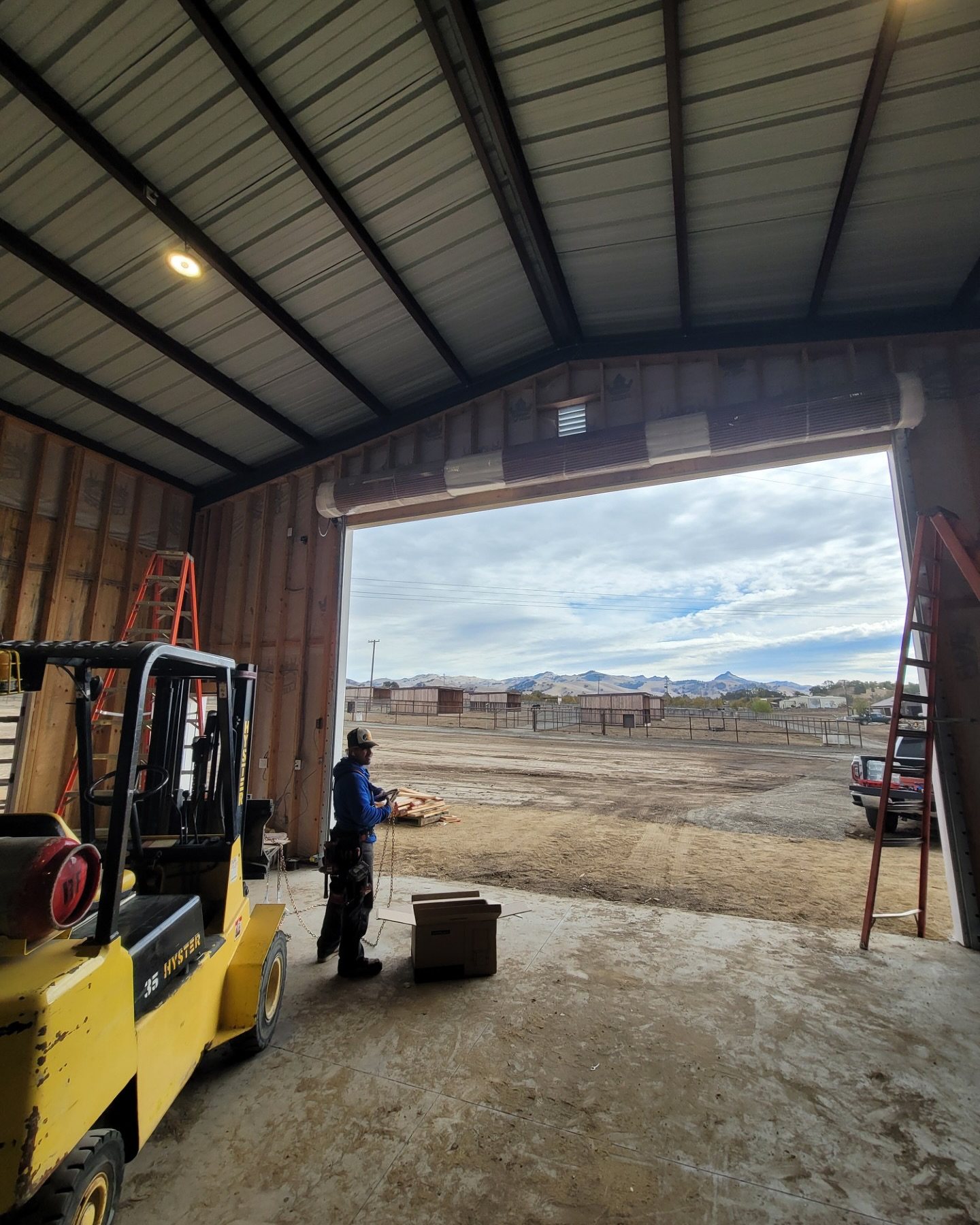 Pole-barn interior with forklift and large door opening